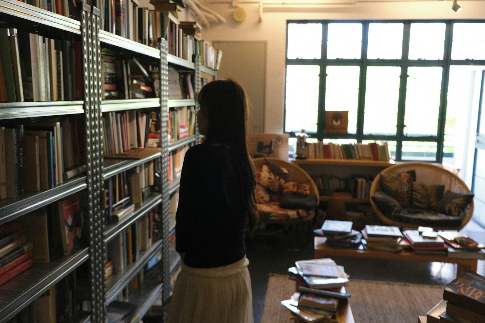 A Woman Browsing Books On Shelves In A Cozy Bookst Jigsaw Puzzle Free Online Jigsaw Puzzle