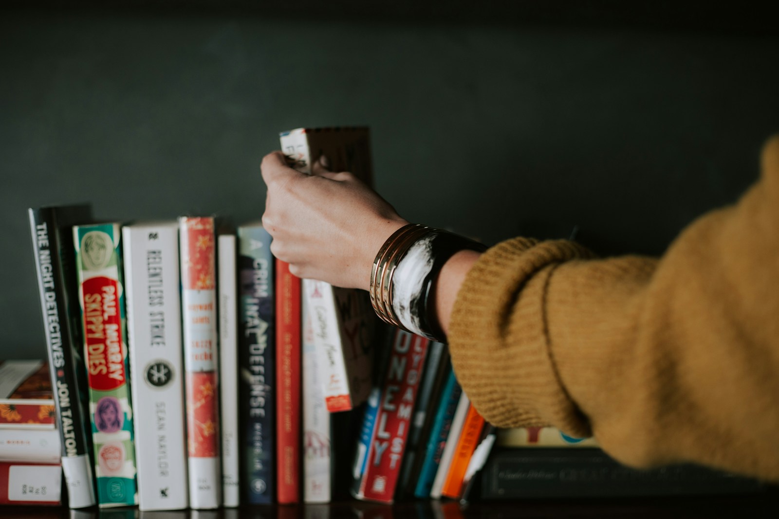 Person Picking White And Red Book On Bookshelf Jigsaw Puzzle Free Online Jigsaw Puzzle