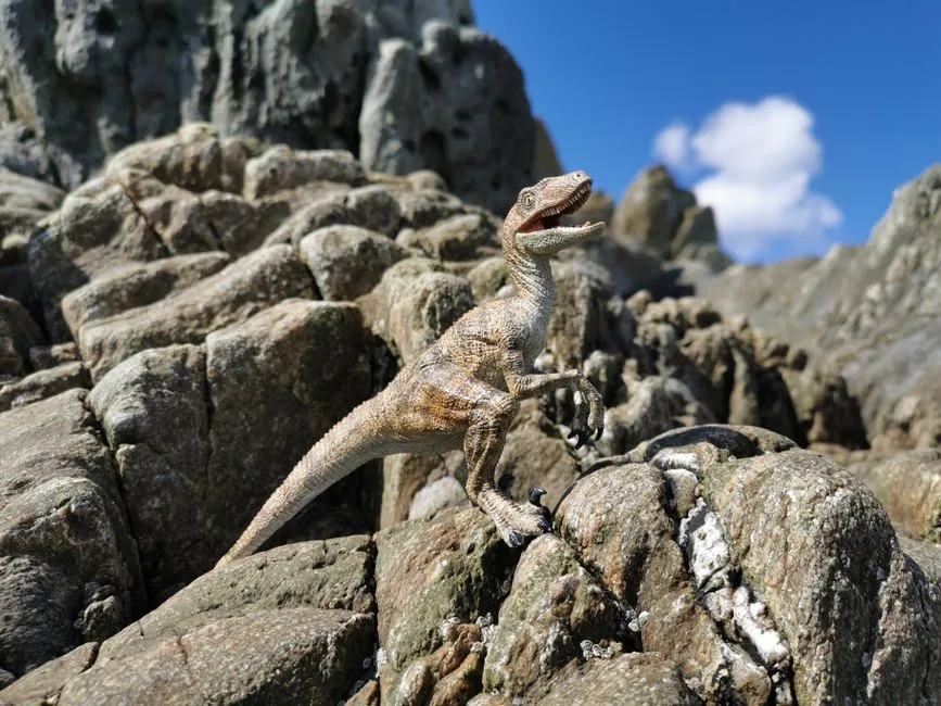A Dinosaur Toy Model Posed On Rocky Formations Wit Jigsaw Puzzle Free Online Jigsaw Puzzle