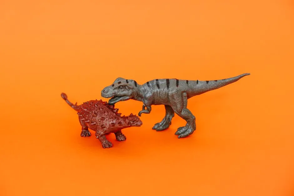 Two Miniature Dinosaur Toys On A Vibrant Orange Ba Jigsaw Puzzle Free Online Jigsaw Puzzle